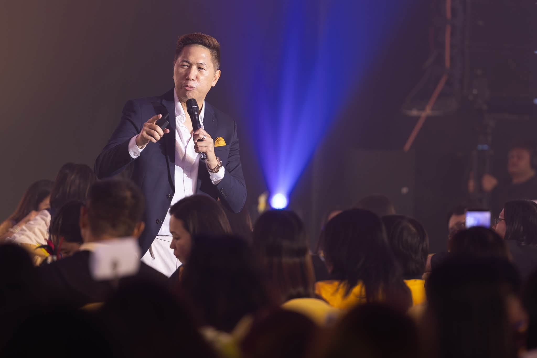 Adrian addressing the room, microphone in hand