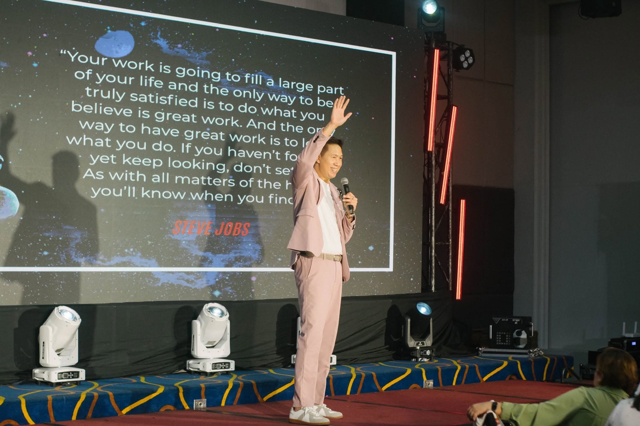 Adrian on stage with a quote projected behind him