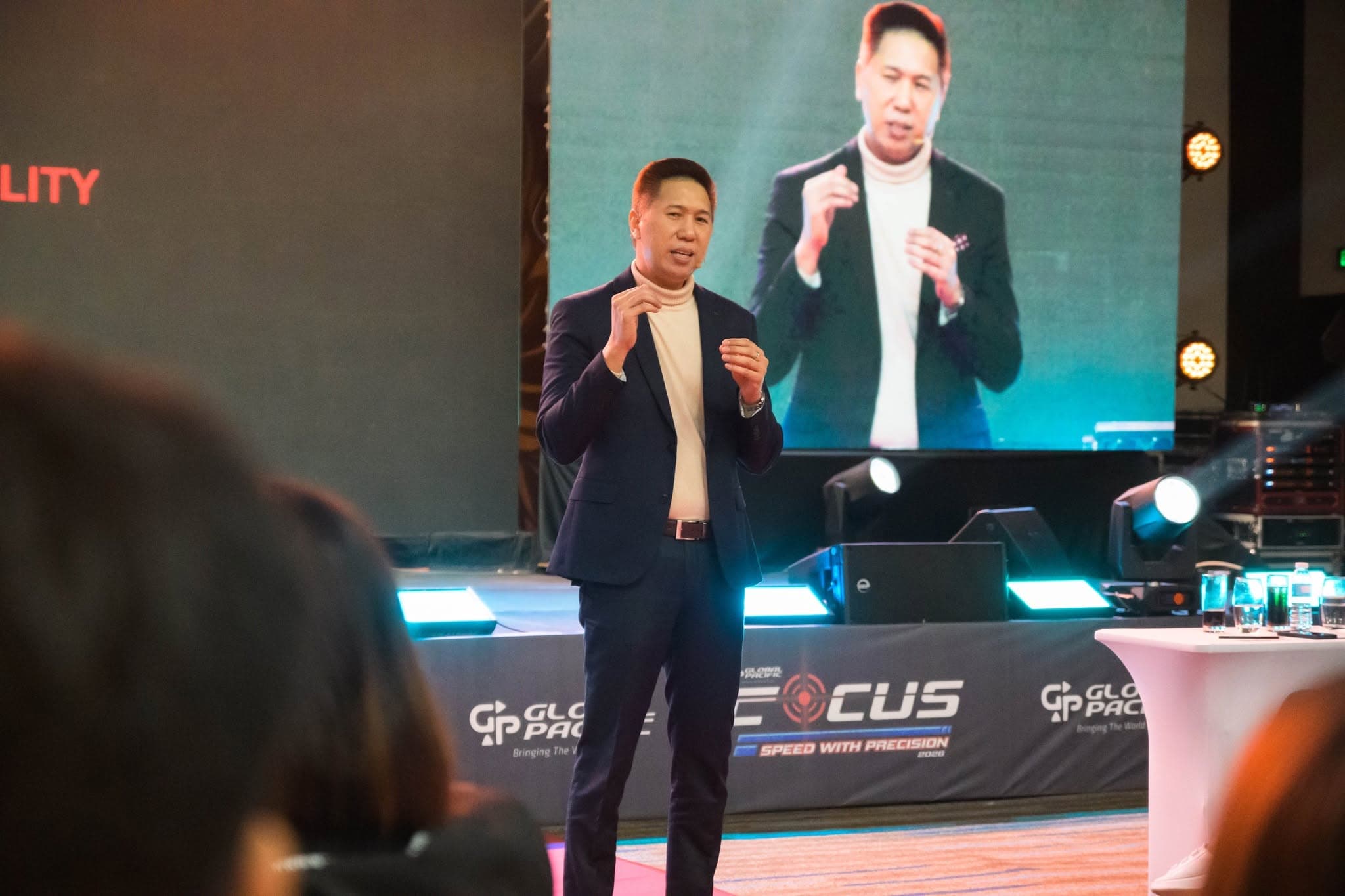 Adrian on stage with his image on the screen behind him