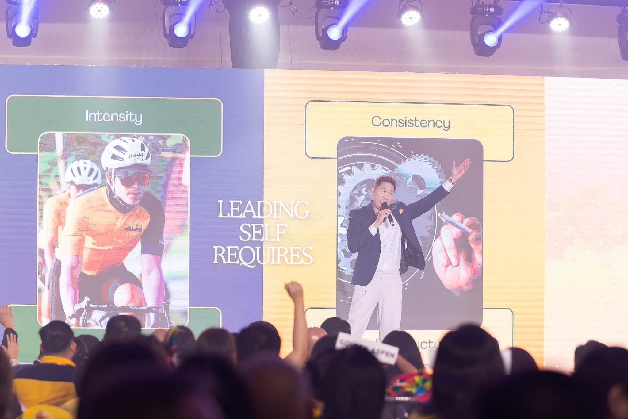 Adrian on stage with the summit's branding behind him